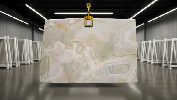 Large marble slab with beige and gray swirls, hanging from a yellow lifting clamp in a spacious warehouse.