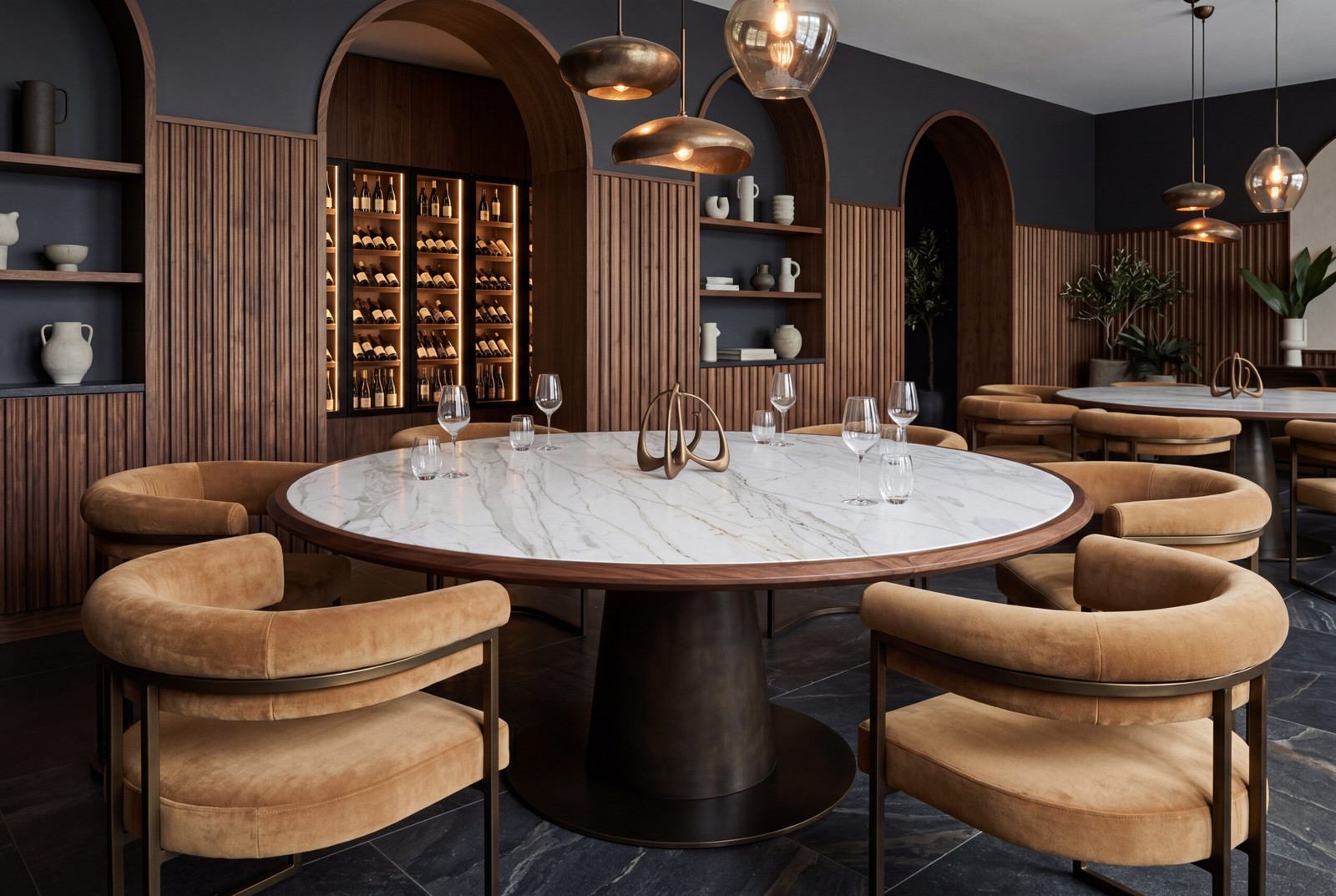 A luxurious wine bar with a round marble table, tan upholstered chairs, and wooden arches lining dark wall shelves filled with bottles.